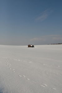 Scenic view of snow covered land against sky