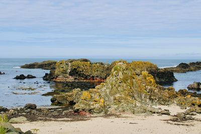 Rocks on beach against sky