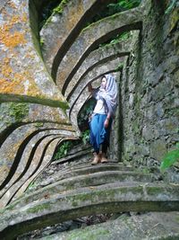 Full length of fashion model standing on rock formation