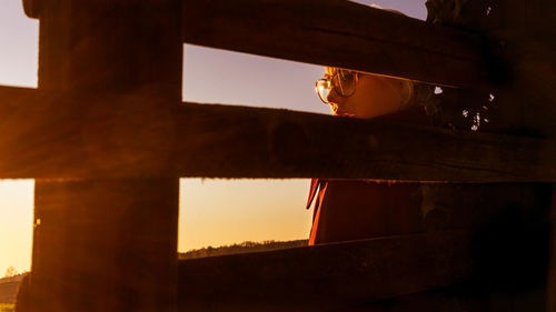 Low angle view of glass window against sky during sunset