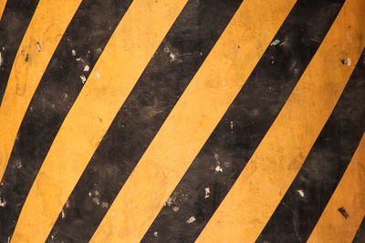 Grunge road markings for pedestrians with yellow and white paints texture.