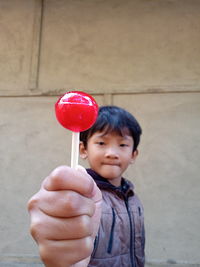 Portrait of cute boy holding lollipop