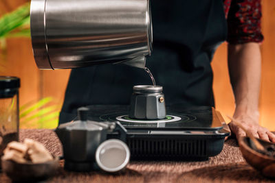 Midsection of woman filtering coffee in cafe