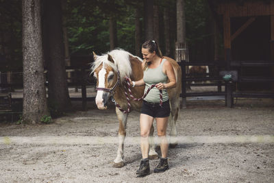 Side view of woman riding horse on road