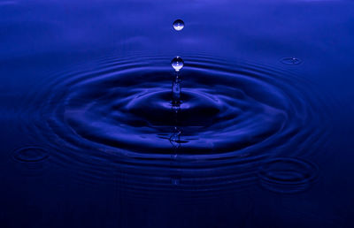 Close-up of drop splashing in blue water