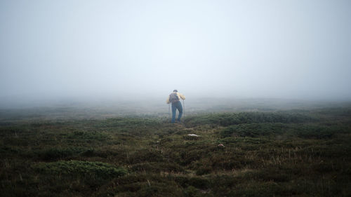 Full length rear view of man standing on land