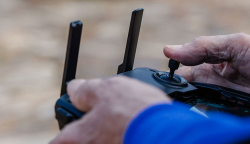 Close-up of old man operating drone using a remote control