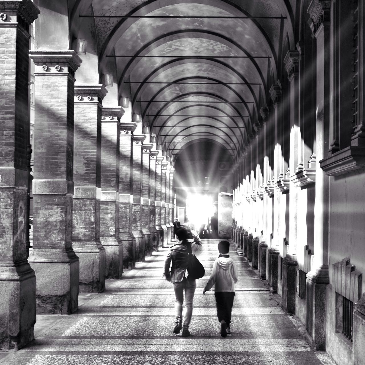 indoors, full length, architecture, the way forward, built structure, walking, lifestyles, rear view, arch, men, corridor, architectural column, person, ceiling, tunnel, leisure activity, diminishing perspective, colonnade, travel