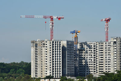 Crane in city against clear sky