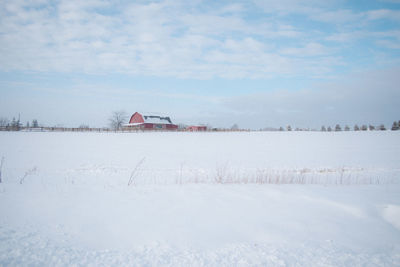 House on field against sky during winter