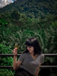 Young woman wearing sunglasses sitting outdoors