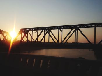 Silhouette bridge against sky during sunset