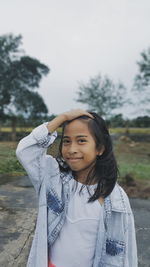 Young woman standing against tree