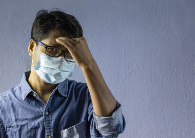 People, health problem and stress concept - unhappy man suffering from headache with nose mask 