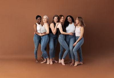 Portrait of friends standing against colored background