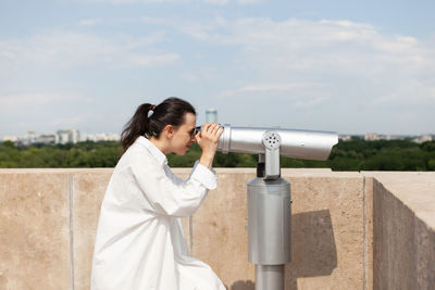 Side view of woman standing against sky