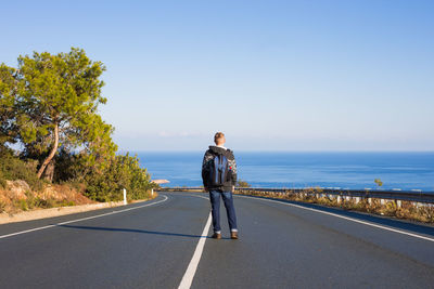 Man standing on road against sky