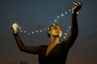 Low angle view of woman standing against sky