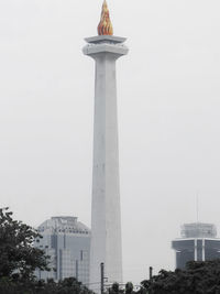 Low angle view of statue in city against sky