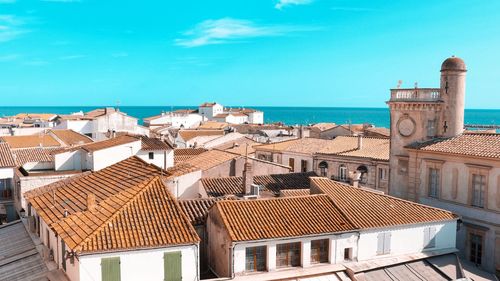 Houses by sea against blue sky