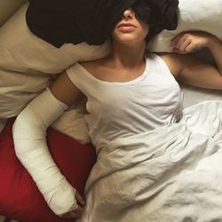 Woman with fractured hand sleeping on bed at home