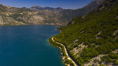 Scenic view of sea and mountains against blue sky