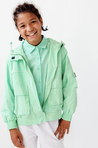 Portrait of young woman standing against white background