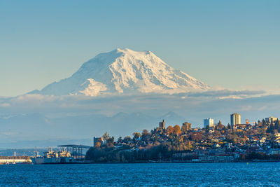 Scenic view of sea by city against sky during winter