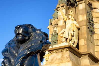 Low angle view of statue against blue sky