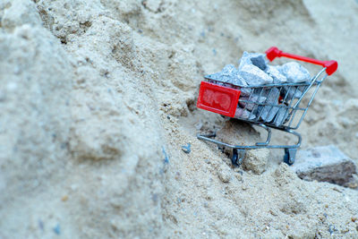 Selective focus on shopping trolley carries the crushed stones on the pile of sand at the site