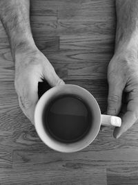 Directly above shot of hand holding coffee cup