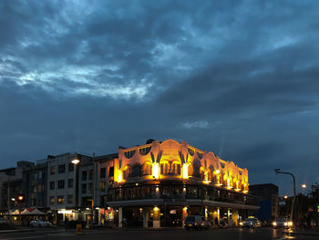 Low angle view of illuminated buildings against sky at night