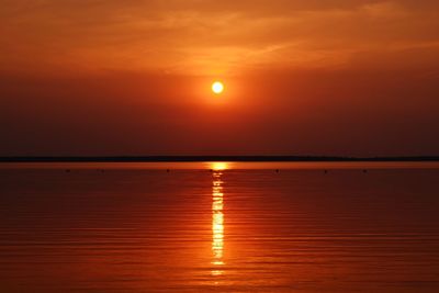 Scenic view of orange sea at sunset