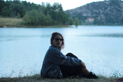 Portrait of woman sitting by lake