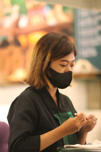 Side view of young woman at a coffeeshop 