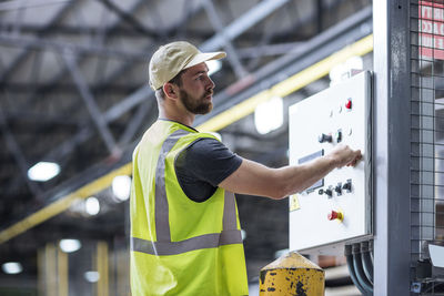 Worker operating machine in factory