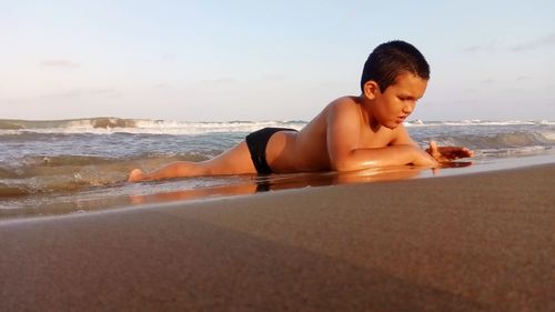 Boy on beach against sky