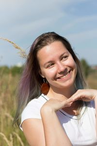 Smiling young woman looking away on field