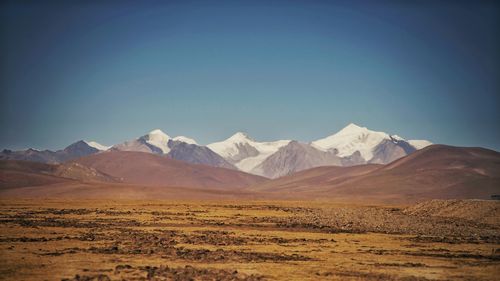 Scenic view of snowcapped mountains against clear blue sky