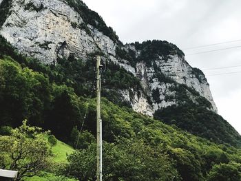 Low angle view of rocks on mountain against sky