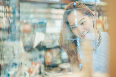 Woman in shopping mall seen through glass window