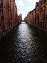 Canal amidst warehouses in city