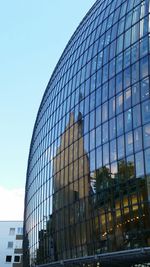 Low angle view of office building against blue sky