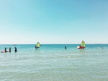 People on beach against clear sky