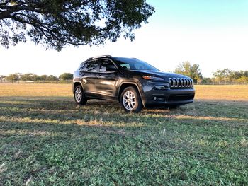 Car on field against clear sky