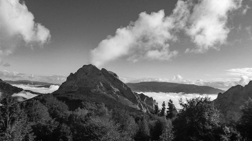 Panoramic view of mountains against white clouded sky