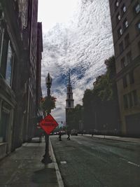 Road sign against sky in city