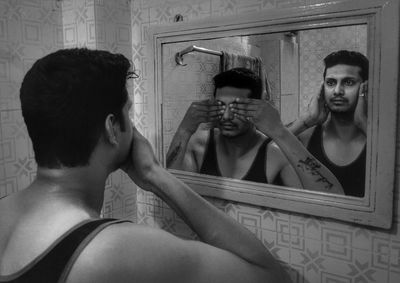 Multiple image of man reflecting on mirror in bathroom