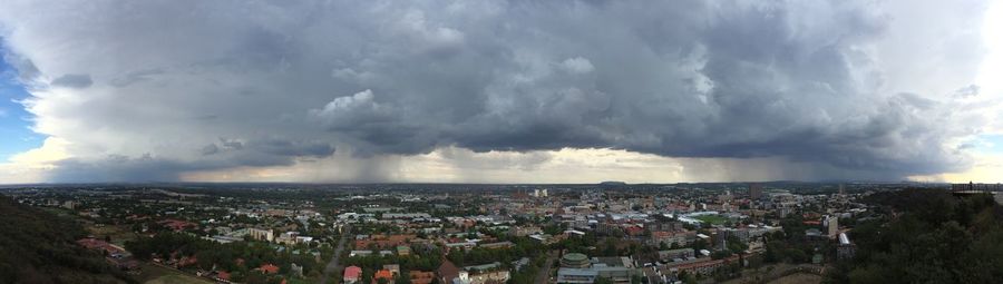 Panoramic view of town against cloudy sky