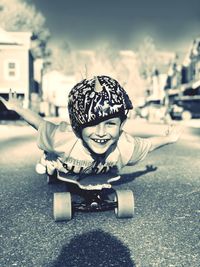 Portrait of boy with umbrella on street in city